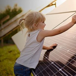 A young girl plays near solar panels