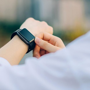 woman in white checking smartwatch on her left wrist