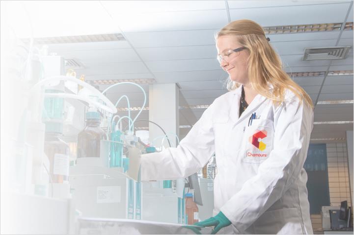 Woman in safety glasses and jacket performing a test
