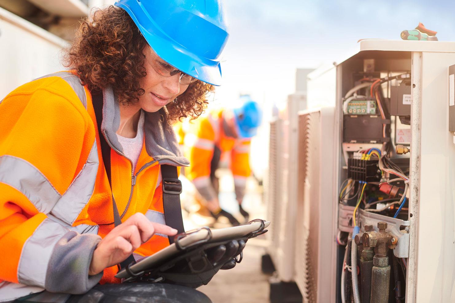 Employees servicing a roof unit