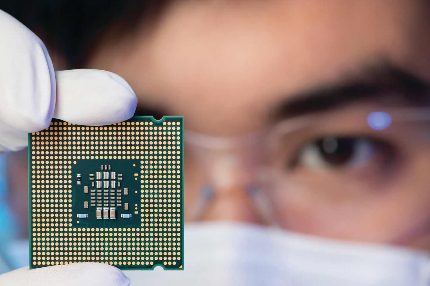 person in glasses and mask holding up a processor