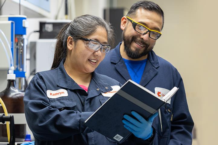 two people looking at a book in a lab