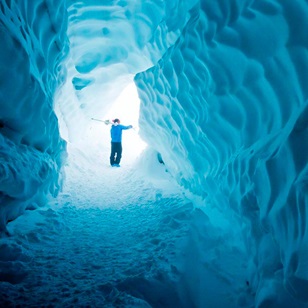 Man standing at the end of an ice tunnel
