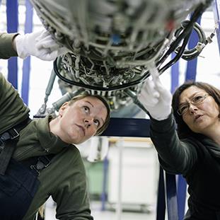 An image of two service technicians fixing an airplane.