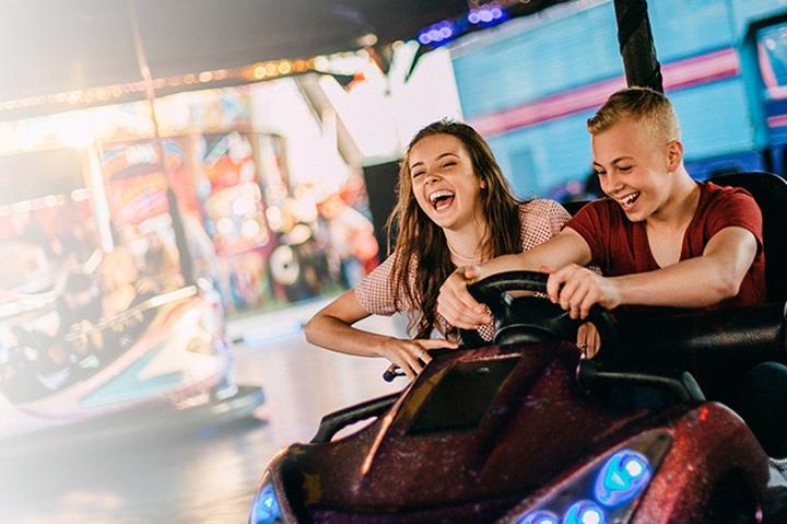 smiling boy and girl in a bumper car ride