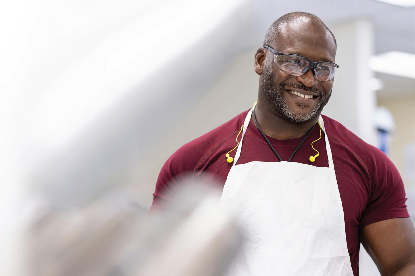 Man wearing safety glasses and an apron