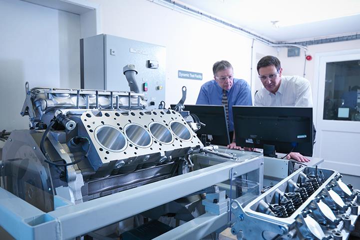 two men looking at computer monitors in a lab or test facilit