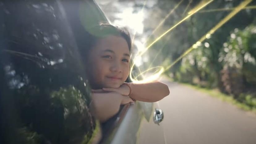 young girl leaning out of a car window