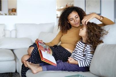 woman and daughter reading a children's book