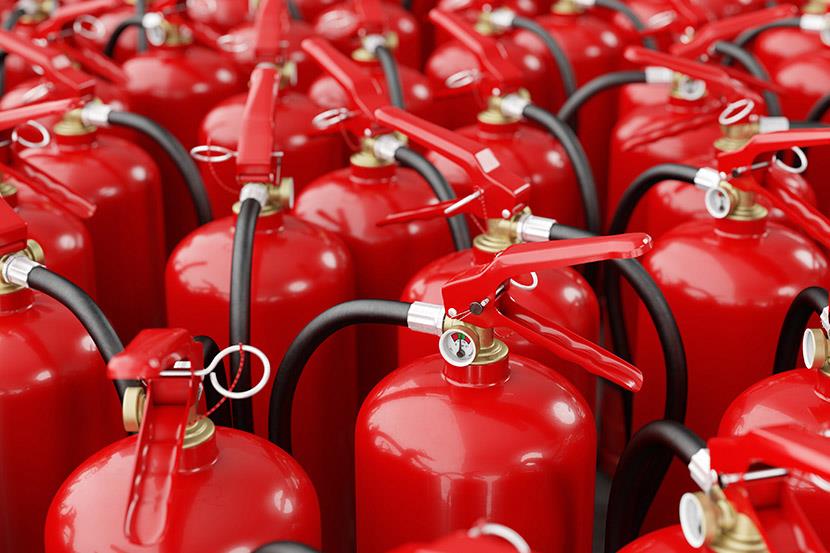 full frame shot of many dozens of red fire extinguishers