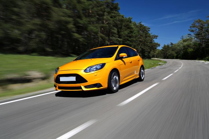Yellow-orange car driving on a road