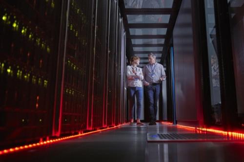 Two people walking through a data center
