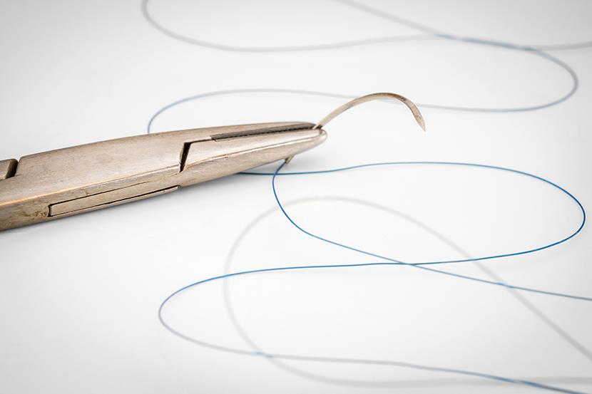 closeup of needle holder and suture