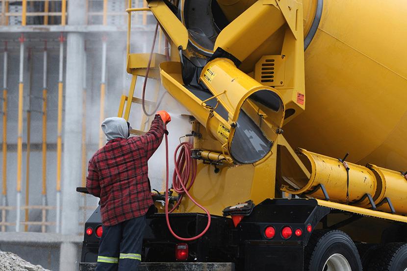 person washing a cement truck