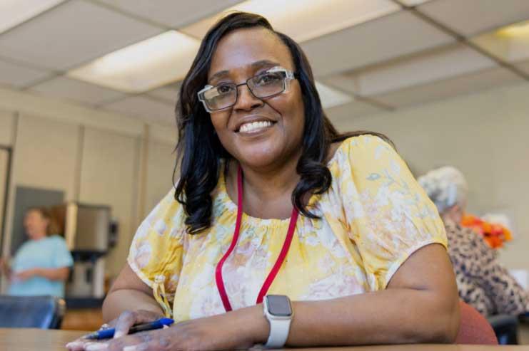Woman in glasses smiling at camera
