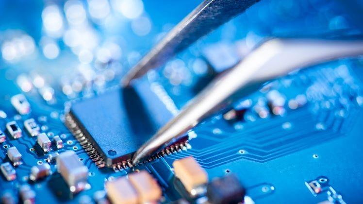 needle nose pliers placing microchip onto circuit board