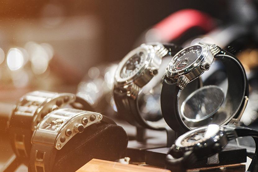 closeup of silver watches with black bands 