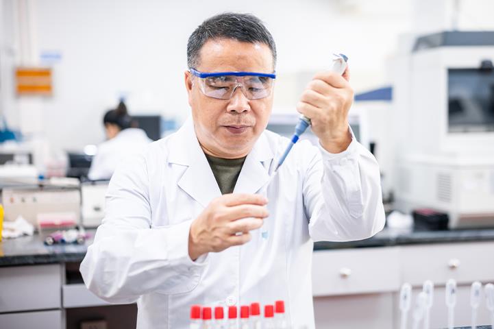 Man filling vial with a pipet