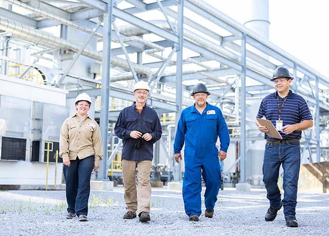 4 employees walking through an outdoor facility