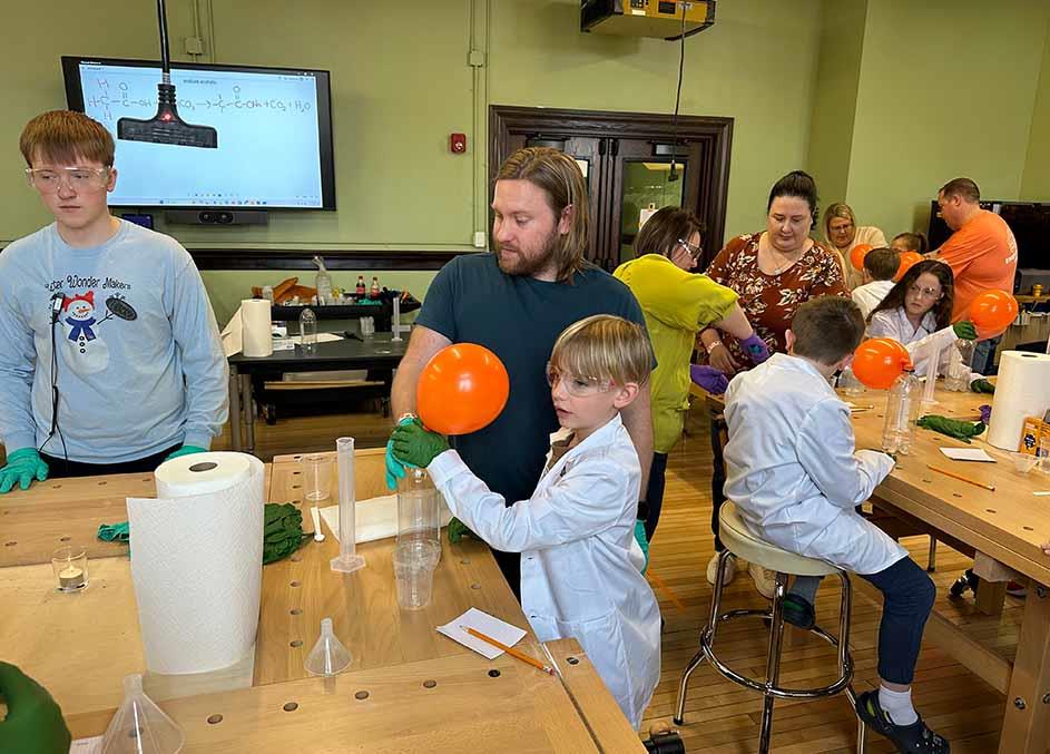 parents and students performing experiments in a classroom