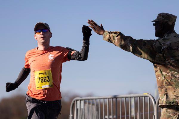runner and military personnel giving each other a high five