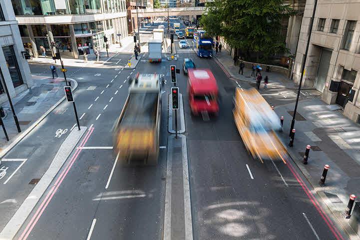 An image of vehicles traveling down a one way highway within the city.