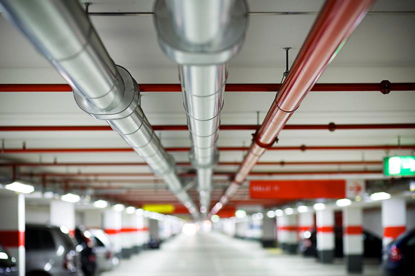 pipes running the length of a parking garage ceiling 