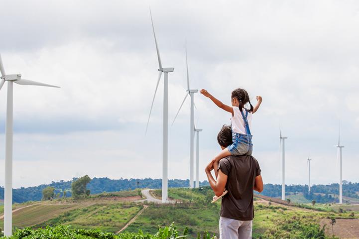 a father shows his daughter windmills