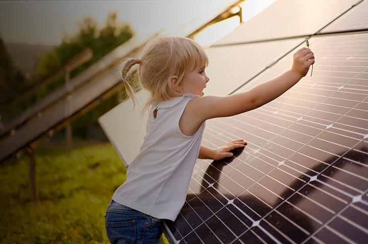 A young girl plays near solar panels