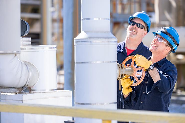 Two employees working on a pipe