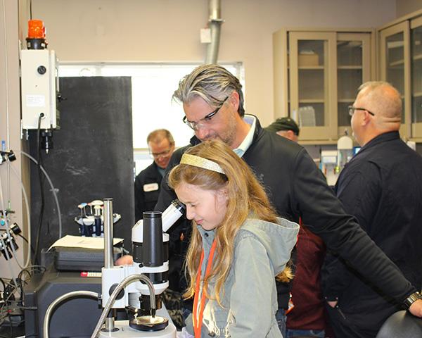child looking through microscope