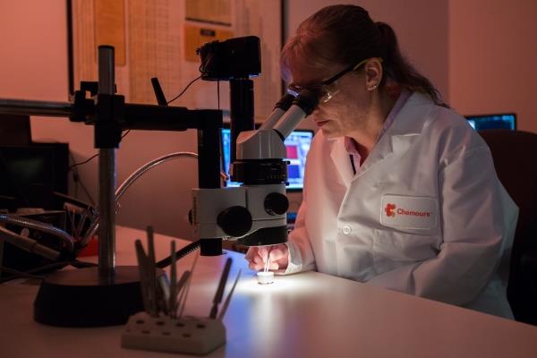 Employee looking through microscope