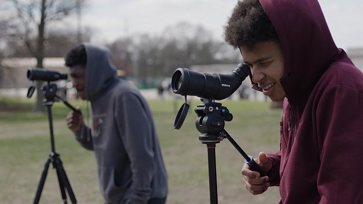 pair of students looking through telescopes