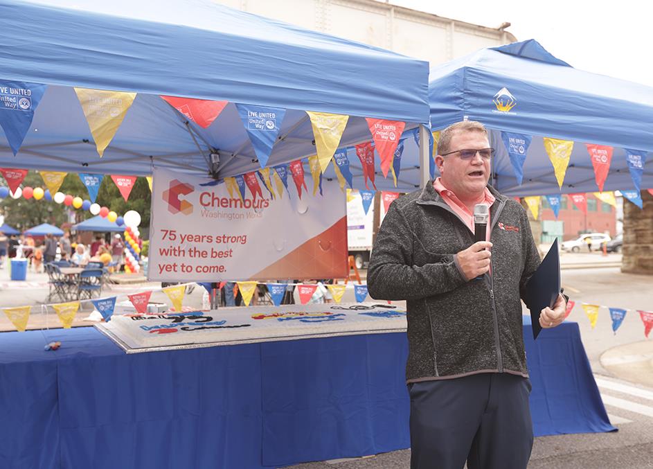 man standing in front of Chemours tent at event