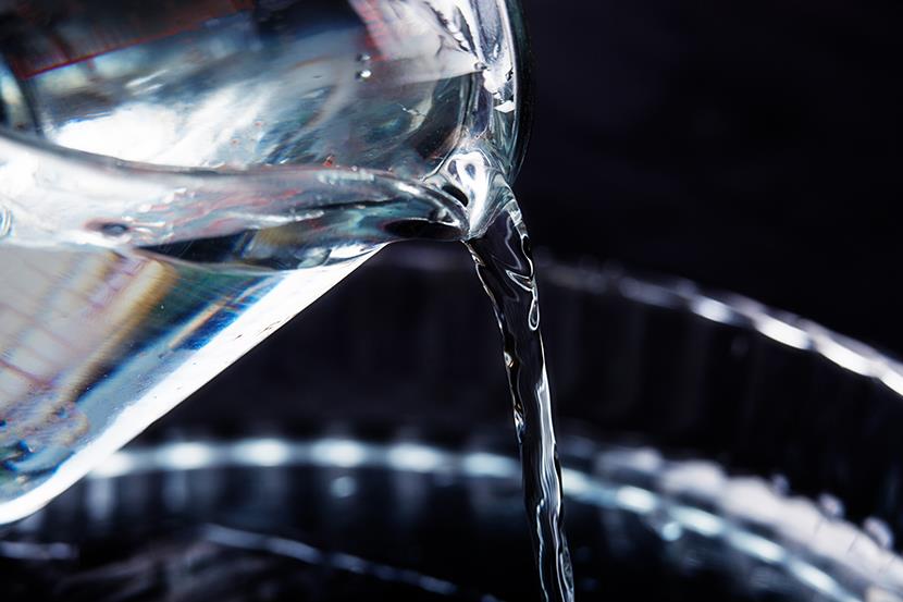 water being poured out of one glass container into another